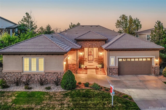 2571 Hunters Pl, Highlands Ranch, CO 80129 - view of front of house with stone siding, stucco siding, a garage, and driveway