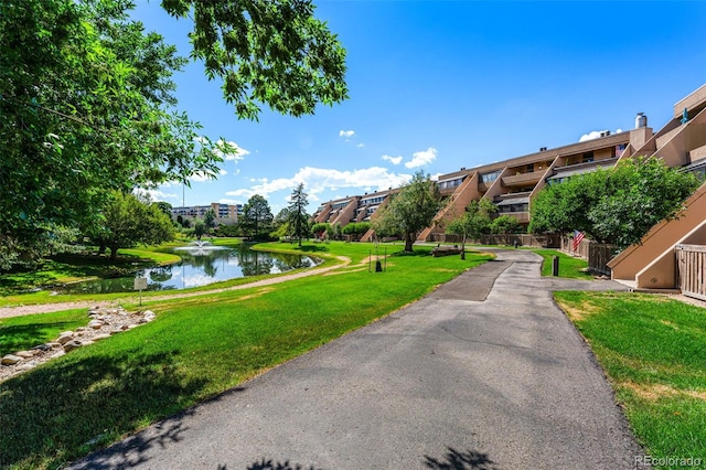 view of community featuring a water view and a yard