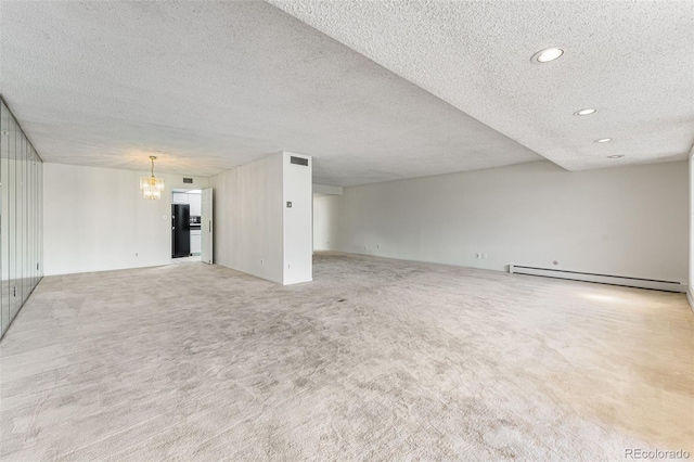 unfurnished living room with a textured ceiling, an inviting chandelier, light carpet, and a baseboard radiator