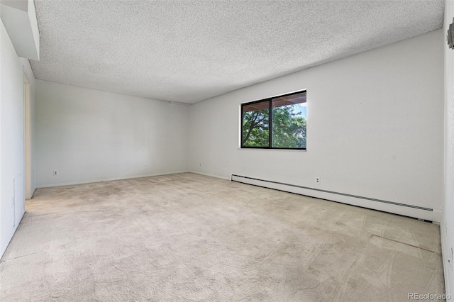 carpeted empty room with baseboard heating and a textured ceiling