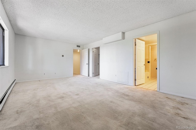 unfurnished room with light colored carpet, a textured ceiling, and a baseboard heating unit