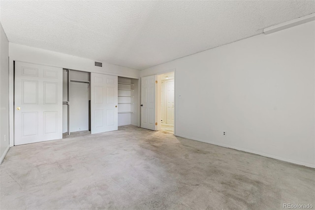 unfurnished bedroom featuring a closet, light colored carpet, and a textured ceiling