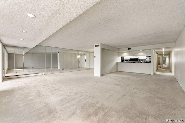 7000 E Quincy Ave Unit 204, Denver, CO 80237 - unfurnished living room featuring a textured ceiling, carpet floors, a baseboard heating unit, and recessed lighting