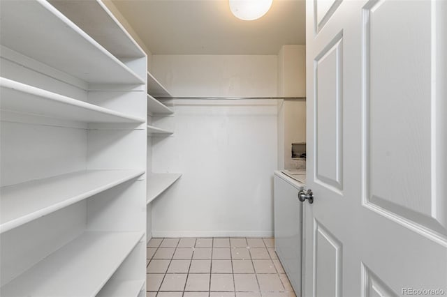 7000 E Quincy Ave Unit 204, Denver, CO 80237 - walk in closet featuring washer / clothes dryer and light tile patterned floors
