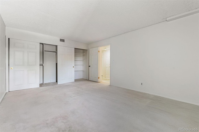 7000 E Quincy Ave Unit 204, Denver, CO 80237 - unfurnished bedroom with a textured ceiling, a closet, light colored carpet, and baseboards