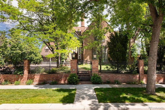 view of front of property with a fenced front yard, brick siding, and a gate