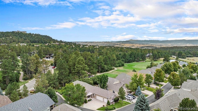 aerial view of residential area featuring a heavily wooded area and mountains