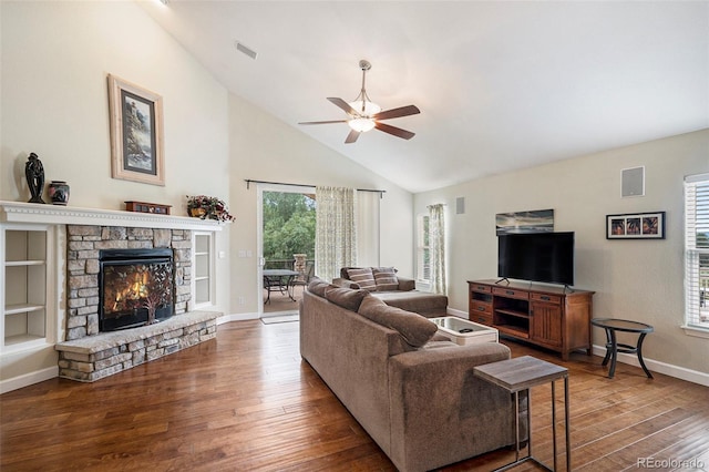 living room featuring a ceiling fan, wood finished floors, a stone fireplace, high vaulted ceiling, and baseboards