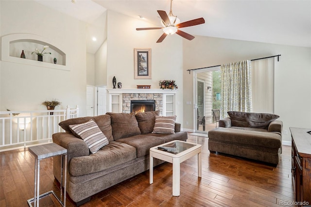 living room featuring high vaulted ceiling, ceiling fan, hardwood / wood-style floors, a fireplace, and baseboards