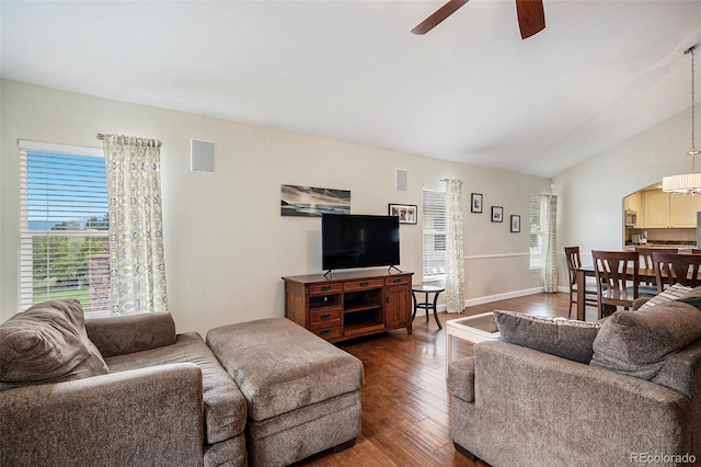 living room featuring plenty of natural light, a ceiling fan, wood finished floors, lofted ceiling, and arched walkways
