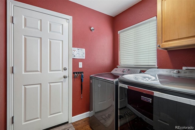 laundry room with cabinet space, independent washer and dryer, a textured wall, dark wood-style floors, and baseboards