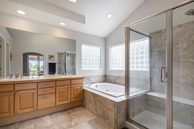 bathroom featuring healthy amount of natural light, lofted ceiling, a stall shower, a bath, and double vanity