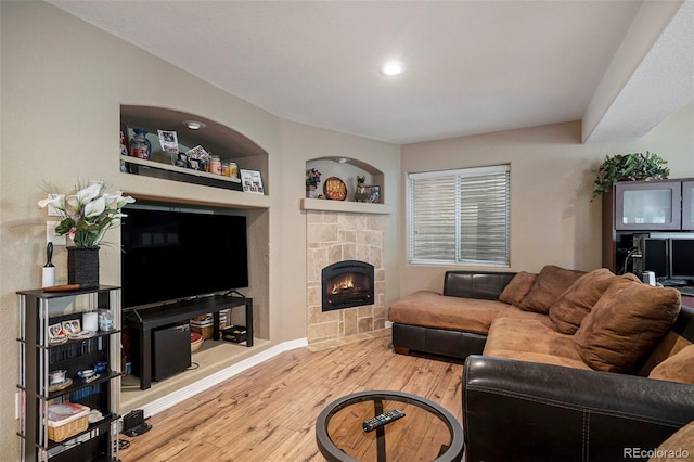 living area with wood finished floors, a fireplace, baseboards, and recessed lighting