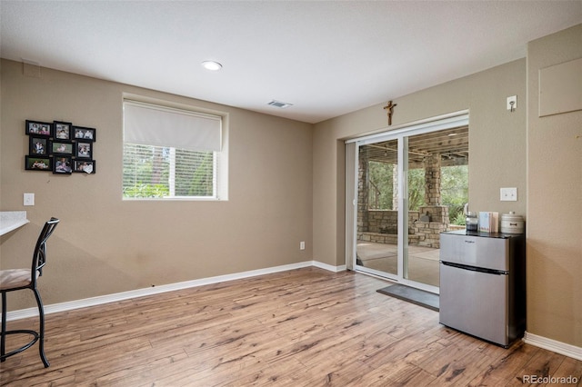 dining room with light wood finished floors, plenty of natural light, baseboards, and recessed lighting