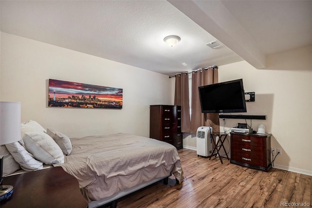 bedroom featuring light wood finished floors and baseboards