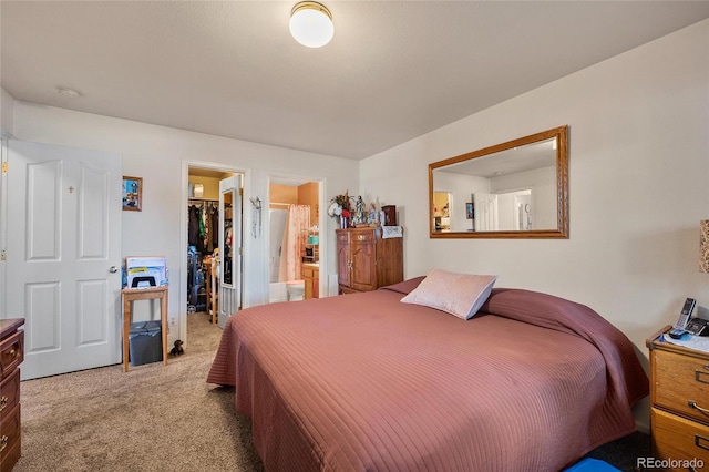 bedroom featuring ensuite bathroom, light carpet, and a spacious closet