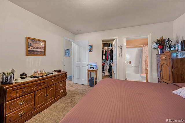 carpeted bedroom featuring a walk in closet, a closet, and connected bathroom