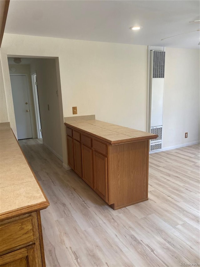 57920 US Highway 285 Unit 23/24, Bailey, CO 80421 - kitchen featuring a heating unit, light wood finished floors, tile counters, and brown cabinets