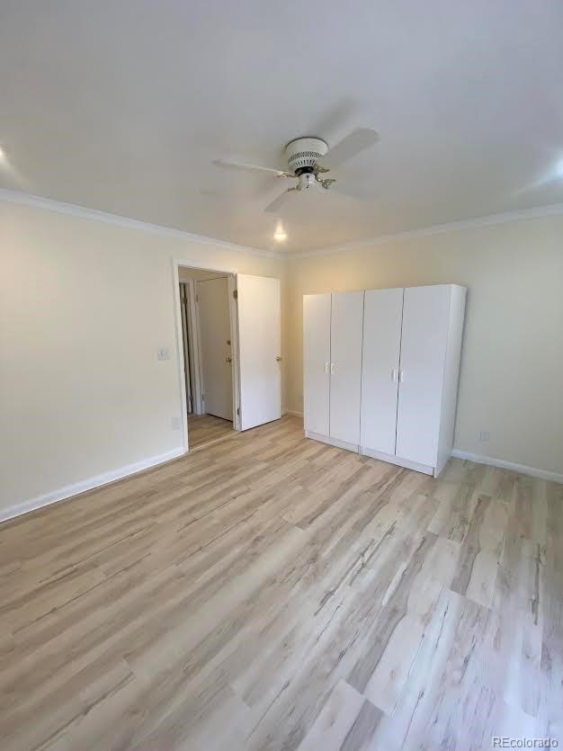 57920 US Highway 285 Unit 23/24, Bailey, CO 80421 - unfurnished bedroom featuring ornamental molding, light wood-type flooring, a closet, and a ceiling fan