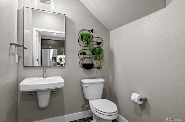 bathroom with toilet and lofted ceiling