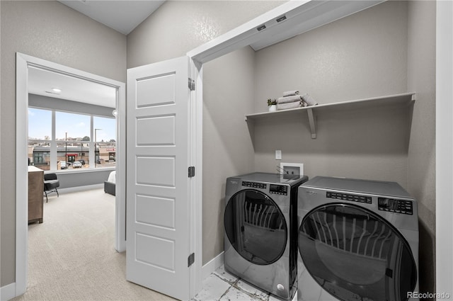 clothes washing area featuring washer and dryer and light colored carpet