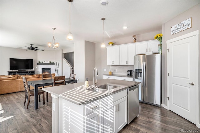 kitchen featuring sink, ceiling fan, stainless steel appliances, white cabinets, and a center island with sink