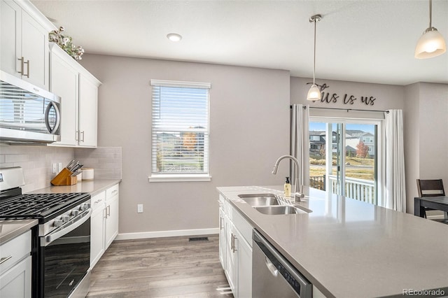 kitchen with pendant lighting, sink, stainless steel appliances, and a healthy amount of sunlight