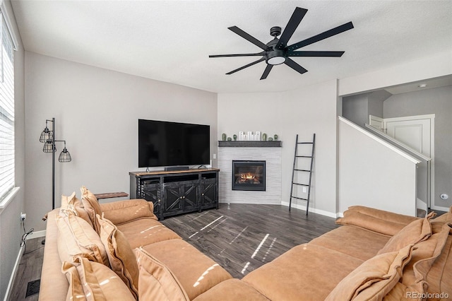 living room with a textured ceiling, ceiling fan, and dark hardwood / wood-style flooring