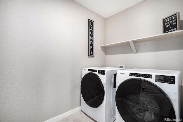 laundry area with washer and dryer and light tile patterned floors