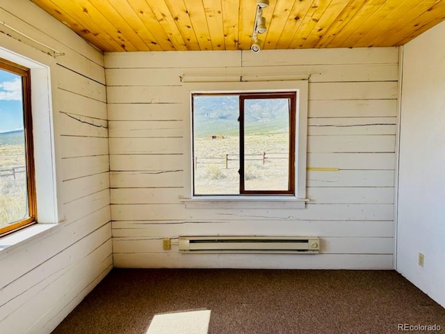 spare room featuring carpet floors, wooden ceiling, and a baseboard radiator