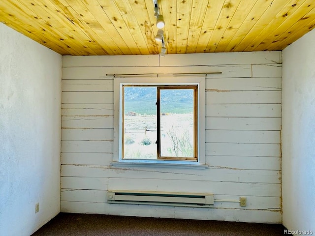 carpeted spare room featuring wood ceiling and a baseboard radiator