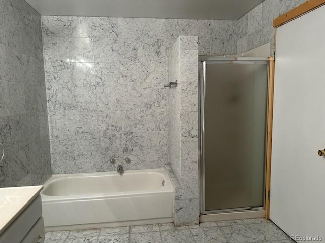 bathroom featuring tile patterned flooring, tile walls, separate shower and tub, and vanity