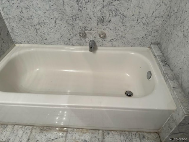 bathroom with tile patterned flooring and a bathing tub