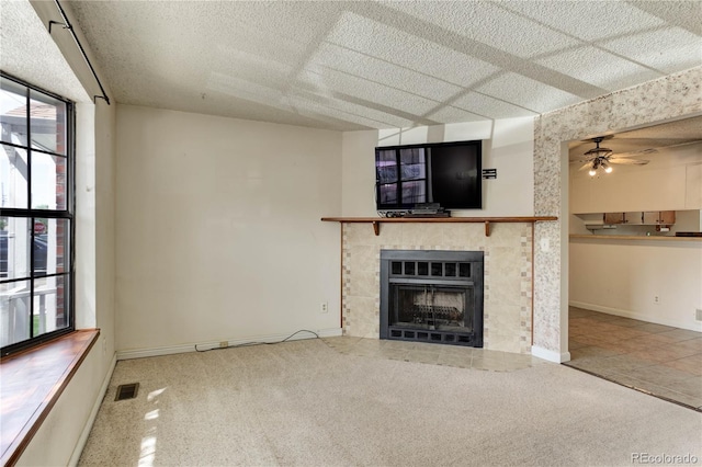 8144 Washington St Unit 192, Denver, CO 80229 - unfurnished living room with plenty of natural light, a ceiling fan, a tile fireplace, baseboards, and a textured ceiling