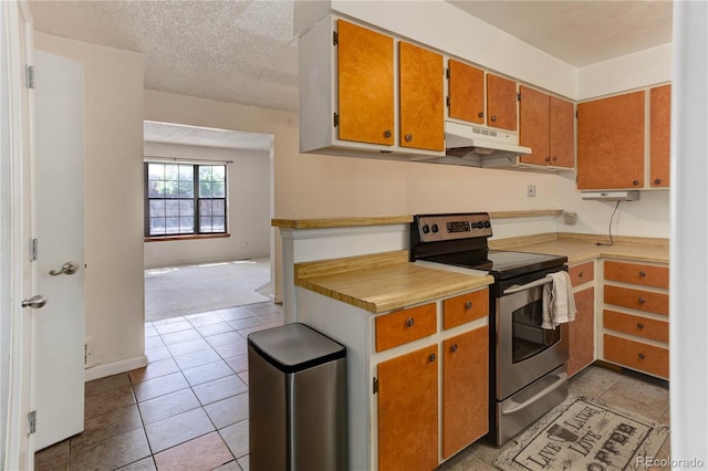 8144 Washington St Unit 192, Denver, CO 80229 - kitchen featuring stainless steel range with electric cooktop, under cabinet range hood, light countertops, light tile patterned floors, and brown cabinets
