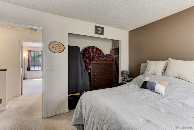 8144 Washington St Unit 192, Denver, CO 80229 - bedroom featuring light colored carpet, a textured ceiling, a closet, and baseboards