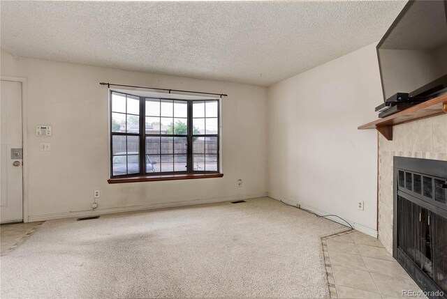 8144 Washington St Unit 192, Denver, CO 80229 - unfurnished living room with a textured ceiling, heating unit, carpet floors, a fireplace, and tile patterned floors