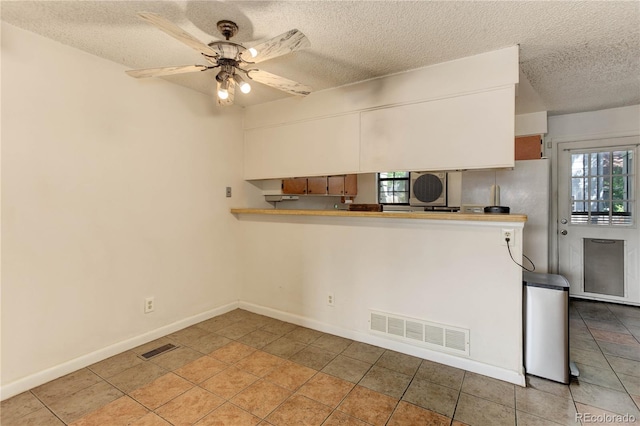 8144 Washington St Unit 192, Denver, CO 80229 - kitchen with a textured ceiling, ceiling fan, baseboards, light tile patterned flooring, and light countertops