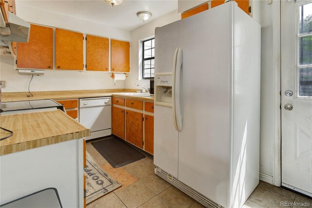 8144 Washington St Unit 192, Denver, CO 80229 - kitchen with white appliances, light tile patterned floors, a sink, and under cabinet range hood