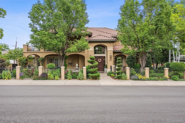 5335 E 2nd Ave, Denver, CO 80220 - mediterranean / spanish home featuring stucco siding, a fenced front yard, a tiled roof, and a gate