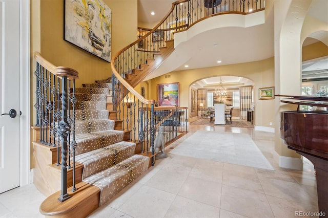 5335 E 2nd Ave, Denver, CO 80220 - tiled entryway featuring arched walkways, a chandelier, a high ceiling, stairway, and recessed lighting