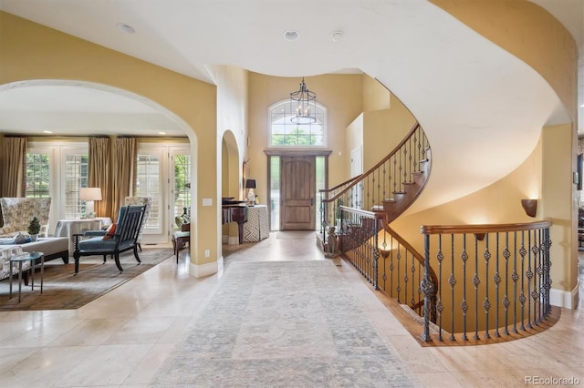 5335 E 2nd Ave, Denver, CO 80220 - tiled entryway with arched walkways, stairway, a chandelier, baseboards, and recessed lighting