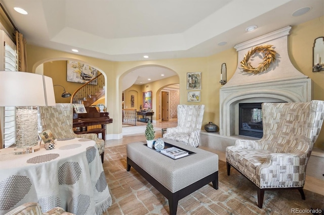 5335 E 2nd Ave, Denver, CO 80220 - sitting room featuring arched walkways, recessed lighting, a fireplace, a tray ceiling, and stairs