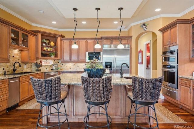 5335 E 2nd Ave, Denver, CO 80220 - kitchen featuring a warming drawer, stainless steel appliances, dark wood finished floors, a sink, and a kitchen island with sink
