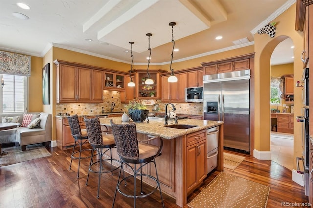 5335 E 2nd Ave, Denver, CO 80220 - kitchen with stainless steel built in refrigerator, a sink, brown cabinets, plenty of natural light, and ornamental molding