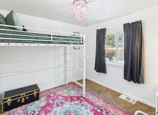 carpeted bedroom featuring visible vents and baseboards