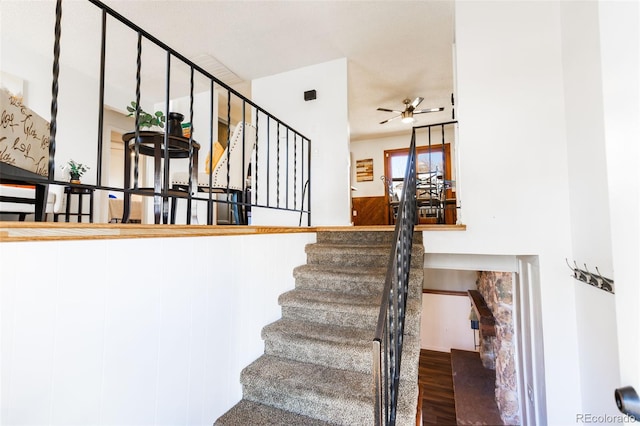 staircase featuring ceiling fan and wood-type flooring