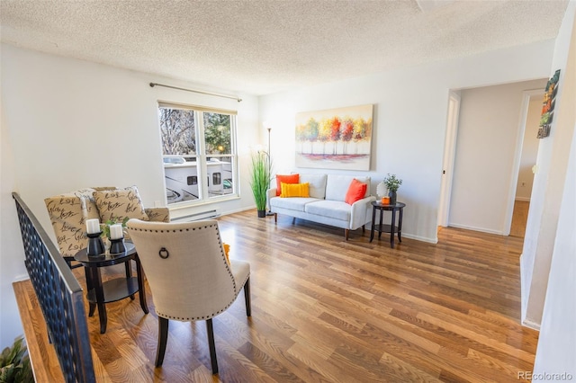 living area with hardwood / wood-style floors and a textured ceiling