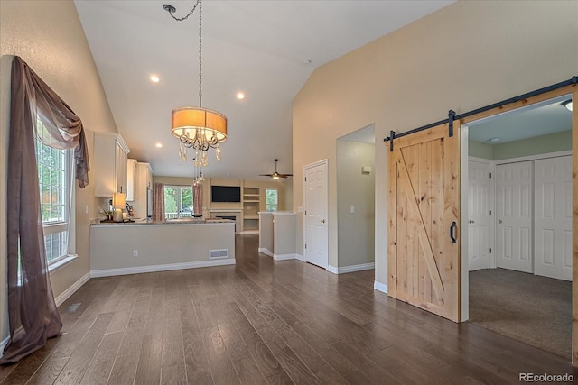 9406 Troon Village Way, Lone Tree, CO 80124 - unfurnished living room featuring a barn door, dark wood-style floors, a chandelier, ceiling fan, and high vaulted ceiling