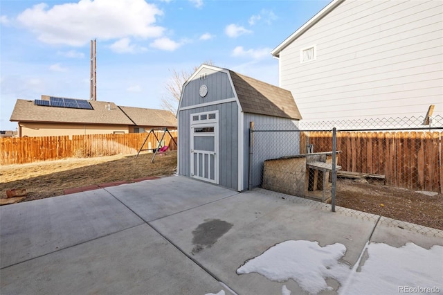 view of patio / terrace featuring a storage shed, an outdoor structure, a fenced backyard, and a garage